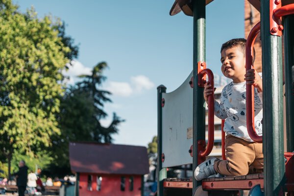 Cheerful child enjoys outdoor playtime on colorful playground equipment