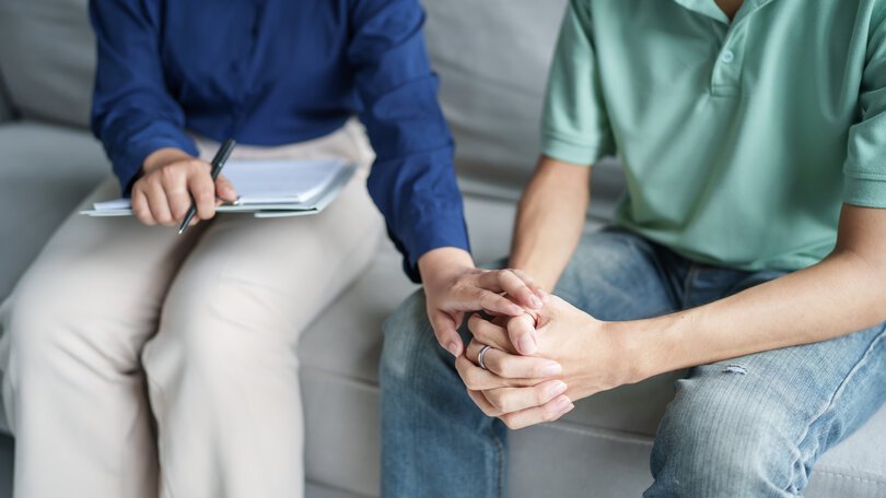 sad male sitting on sofa Patient discussing mental health issues with psychologist. depressed asian man mental health treatment concept