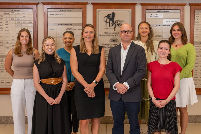 A smiling group of people stands together for a photo.