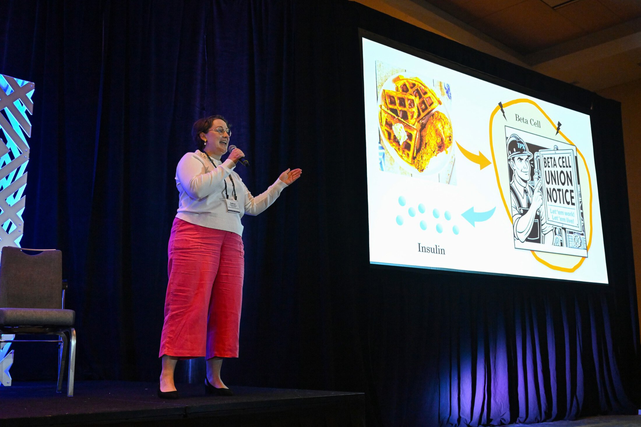 Ph.D. student stands on stage giving a presentation.