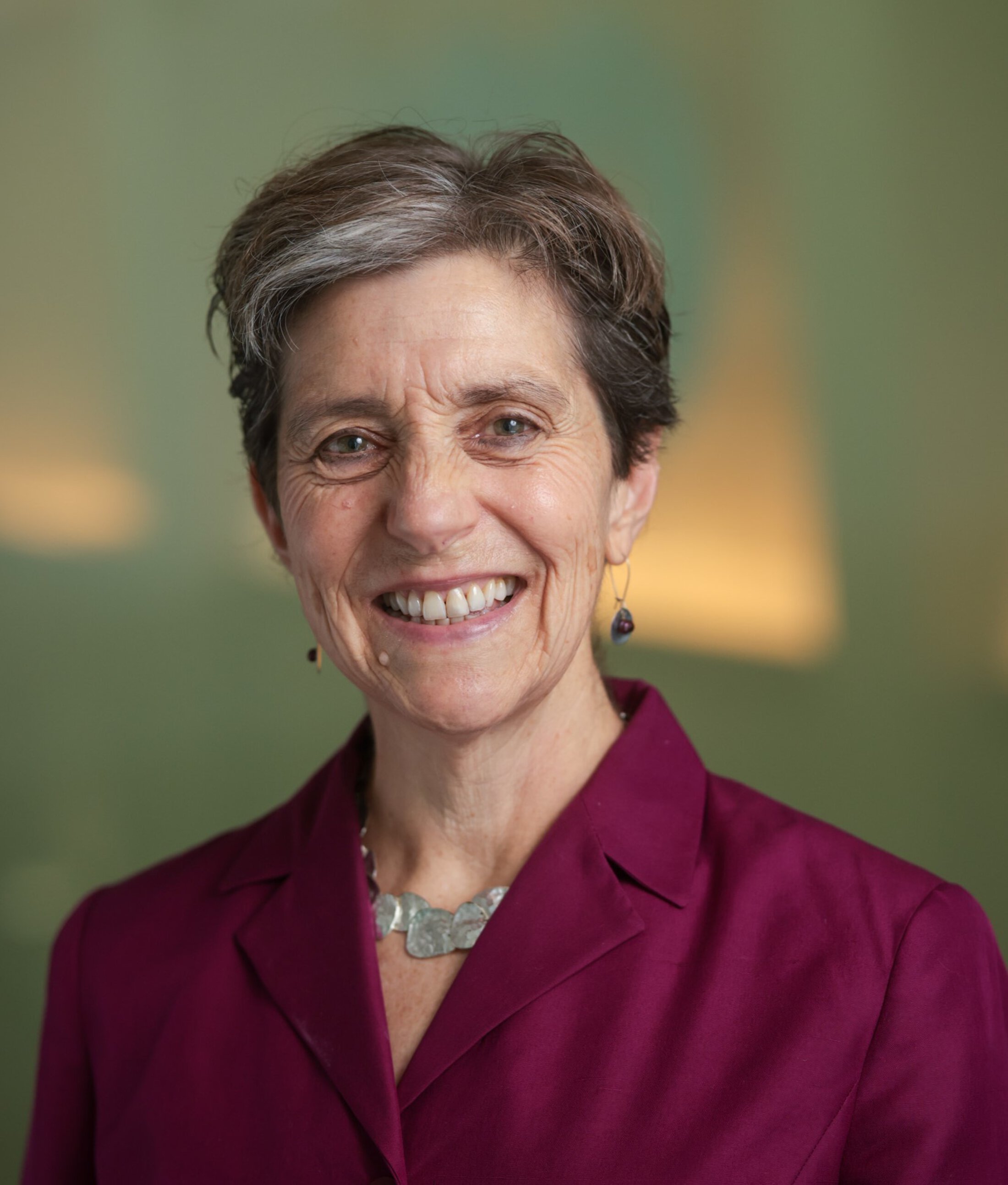Dr. Nancy Kass wearing a colorful dress shirt with a necklace profile image