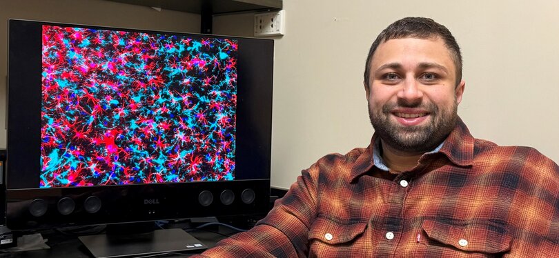In his office, Khalil Mallah, Ph.D., pulls up a rendering illustrating neuroimmune activity on his computer screen.