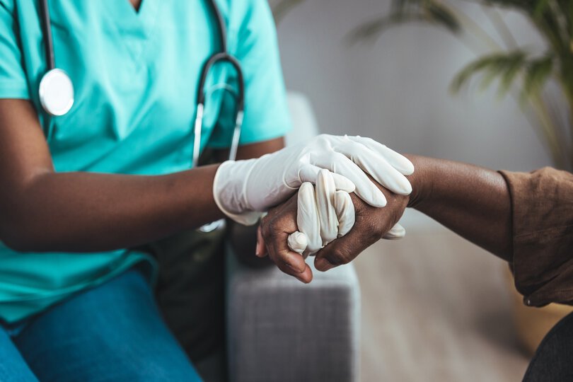 Cropped shot of a female nurse hold her senior patient's hand. Giving Support. Doctor helping old patient with Alzheimer's disease. Female carer holding hands of senior man