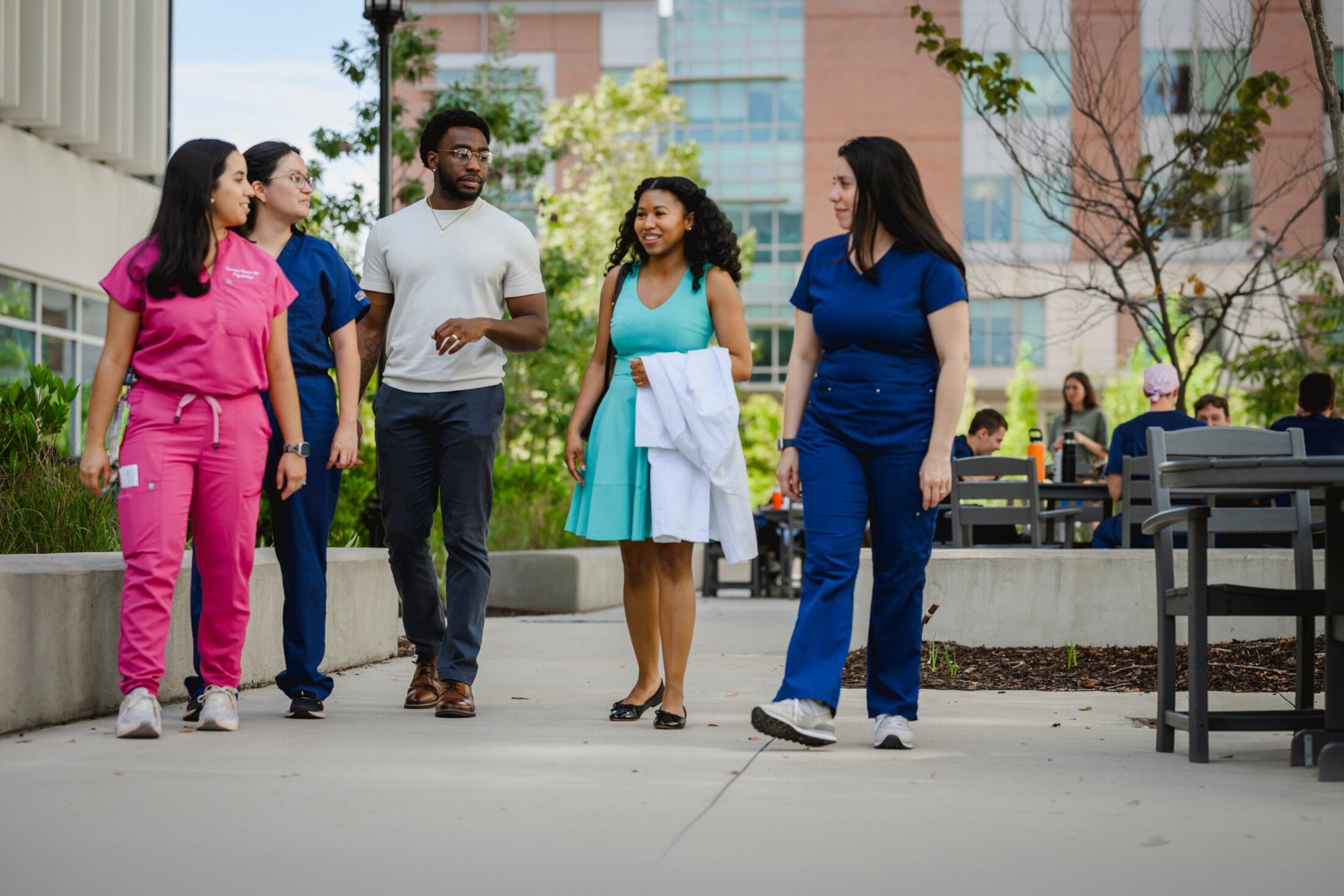 Residents (Vanessa Navas, Sofia Goyonaga-Calatayud, Uriah Chapman, Faith Middleton, Maria Montalvan Padilla) walking on MUSC campus
