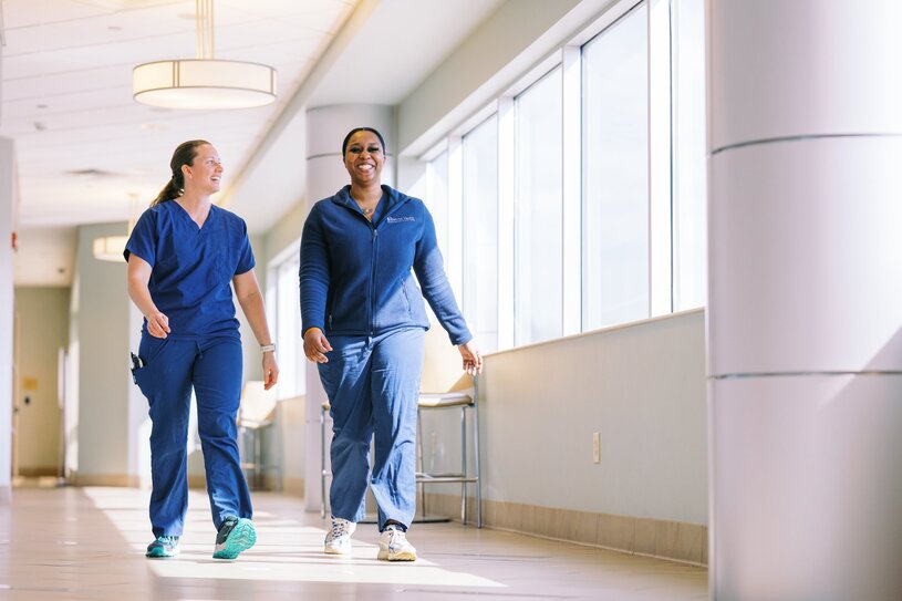 Kristen Anderson and Johnkei Myers, Nurses, walking and talking in a hallway at Columbia Medical Center Northeast.