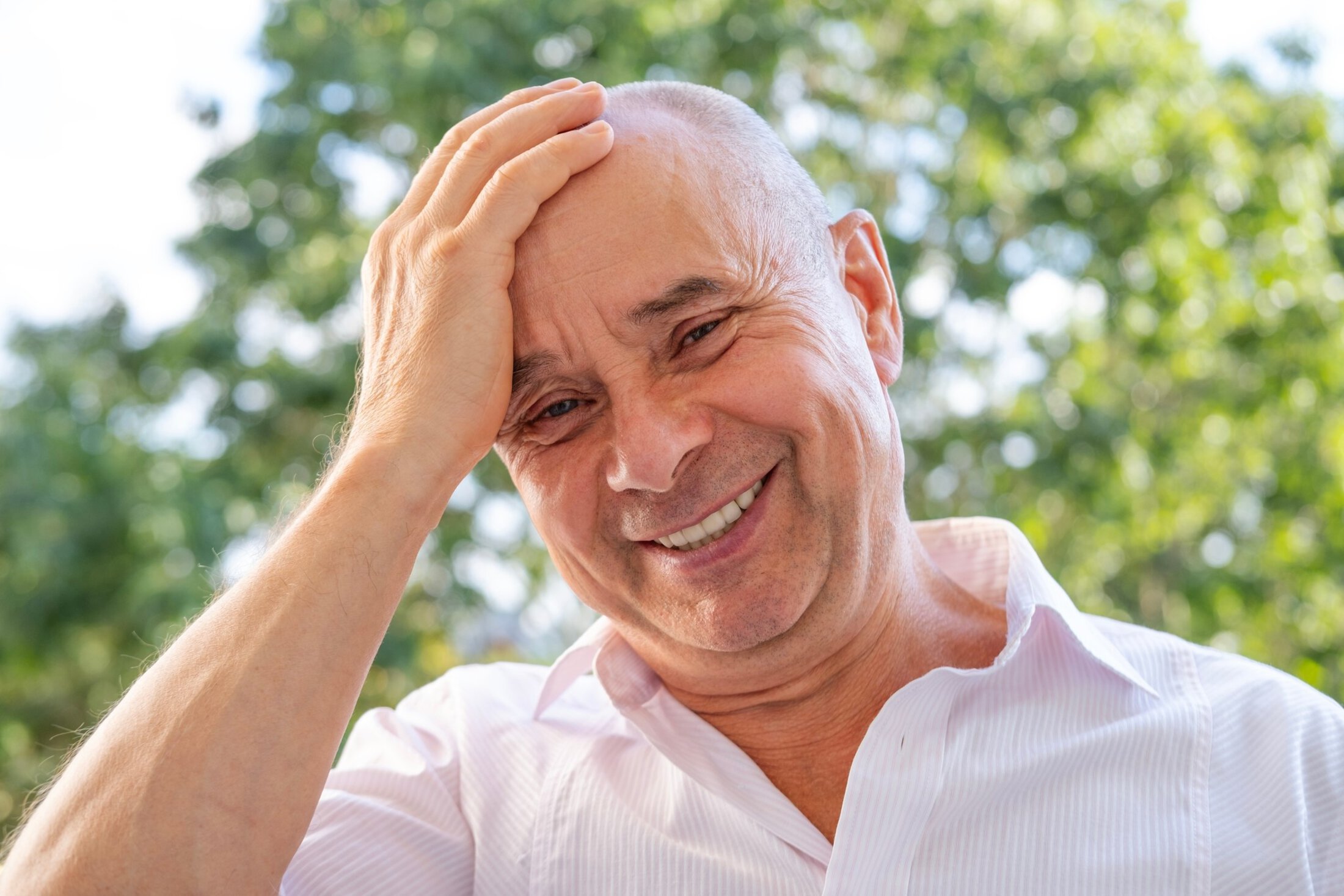 happy elderly gentleman, caucasian Elderly man 60-65 years old smiling on green natural background, close-up face, good mood, age-related changes, concept mental human health, optimism in adulthood