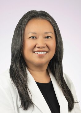 Dr. Ho is a board-certified family medicine physician wearing a white coat