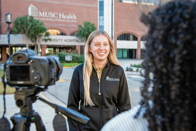 Medical University of South Carolina (MUSC) n the news. A student is interviewed on the news in front of the university hospital.