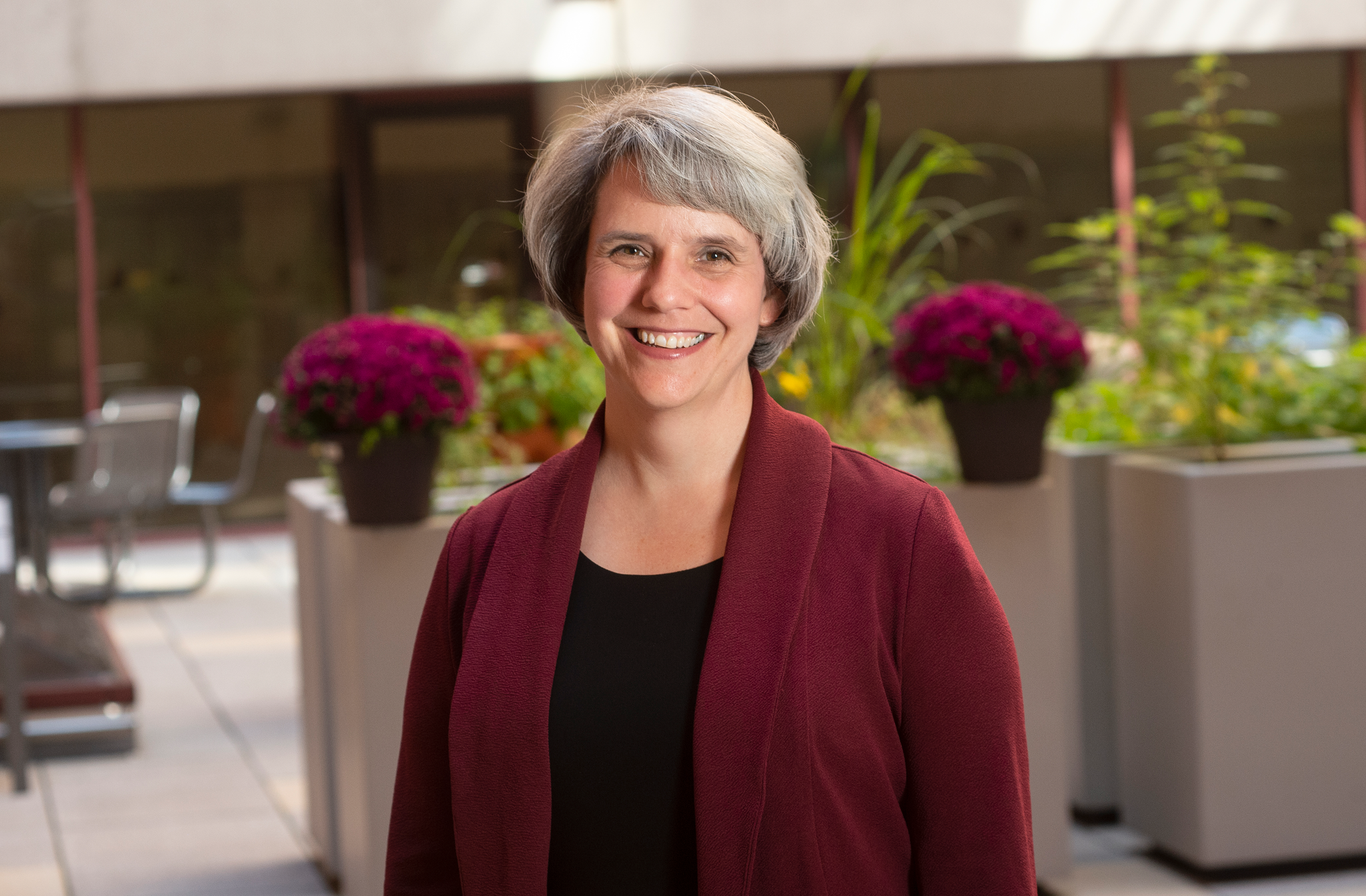 Outdoor portrait of a woman in a garden setting.
