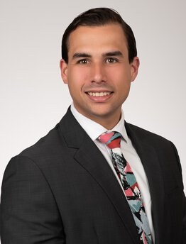 Ricardo Domingo Cabrej wearing a grey sport coat and dress shirt and tie