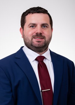 Christopher Frazier headshot wearing a blue suit with red tie