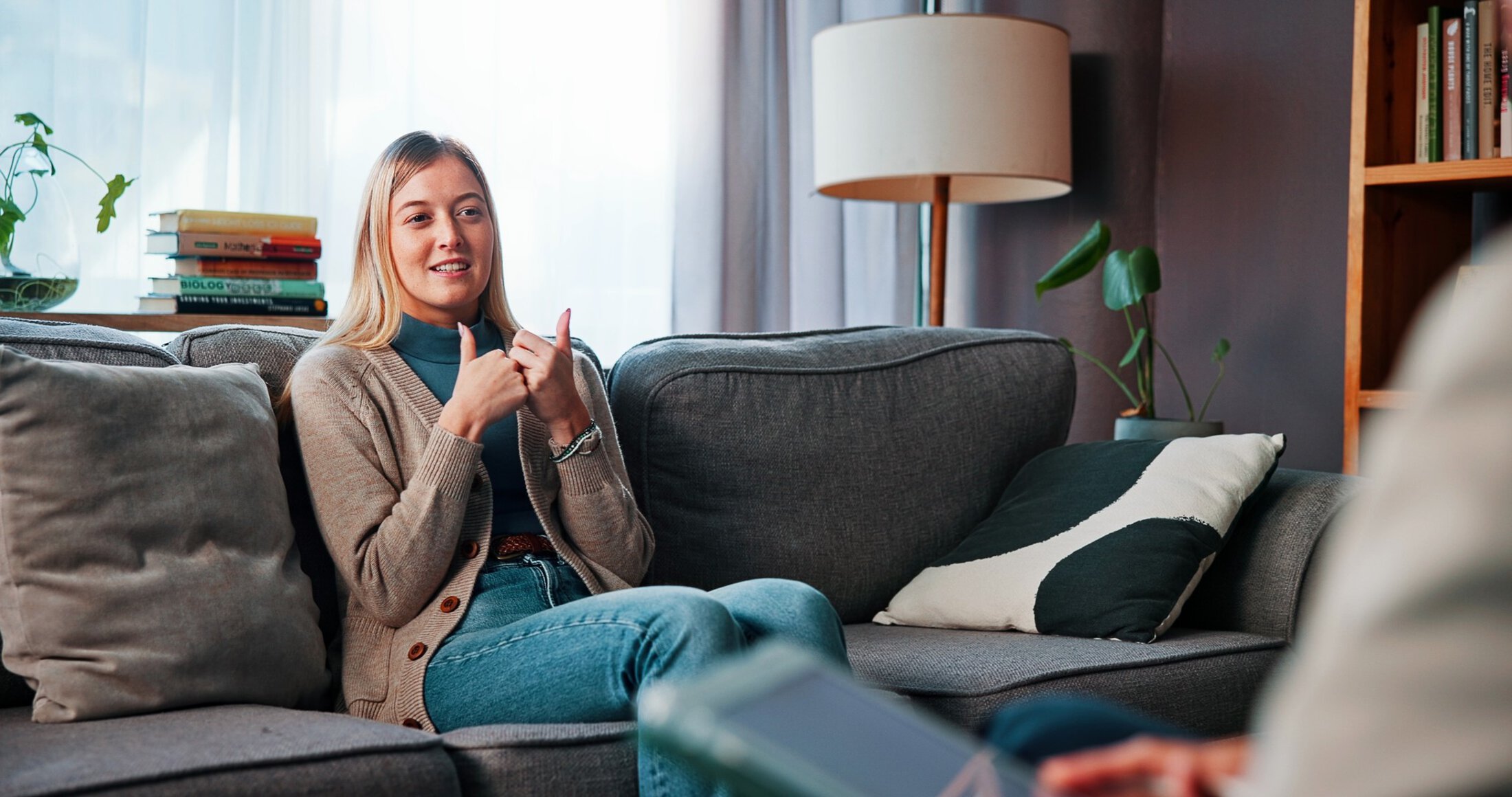 Woman, psychology and speaking with psychologist for mental health, advice and trauma recovery. Client, therapy and consultation in counseling session for healing, smile or help with ptsd in office