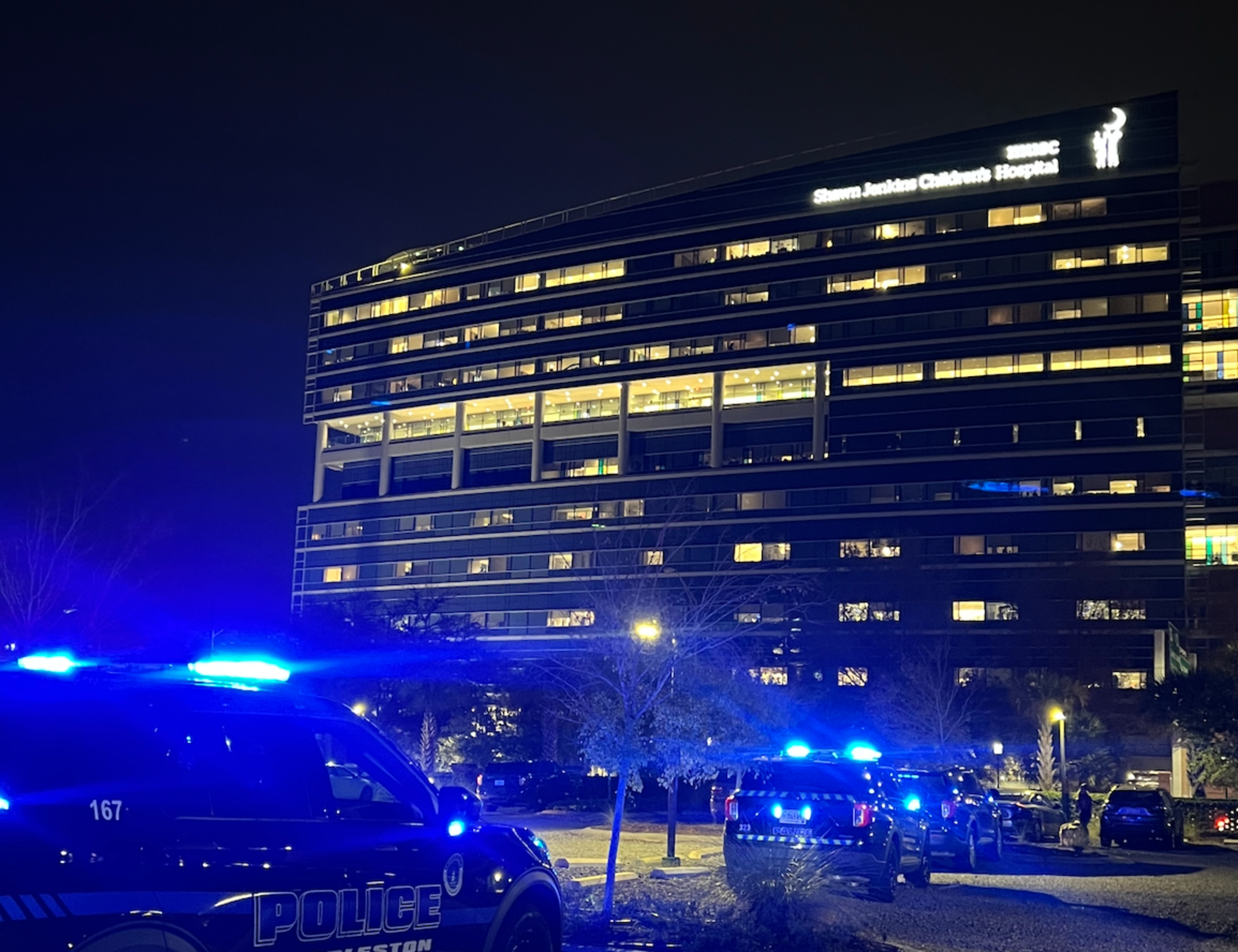 MUSC Shawn Jenkins Children's Hospital exterior evening image of building with police cars for the parade.