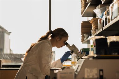 A doctor in the lab viewing samples using a magnifying scope
